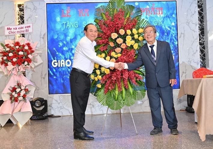 Ông Huỳnh Văn Hồng (bìa trái), Chủ tịch Hội Văn học Nghệ thuật tặng hoa chúc mừng tác giả Lê Huy Mậu tại lễ ra mắt.
